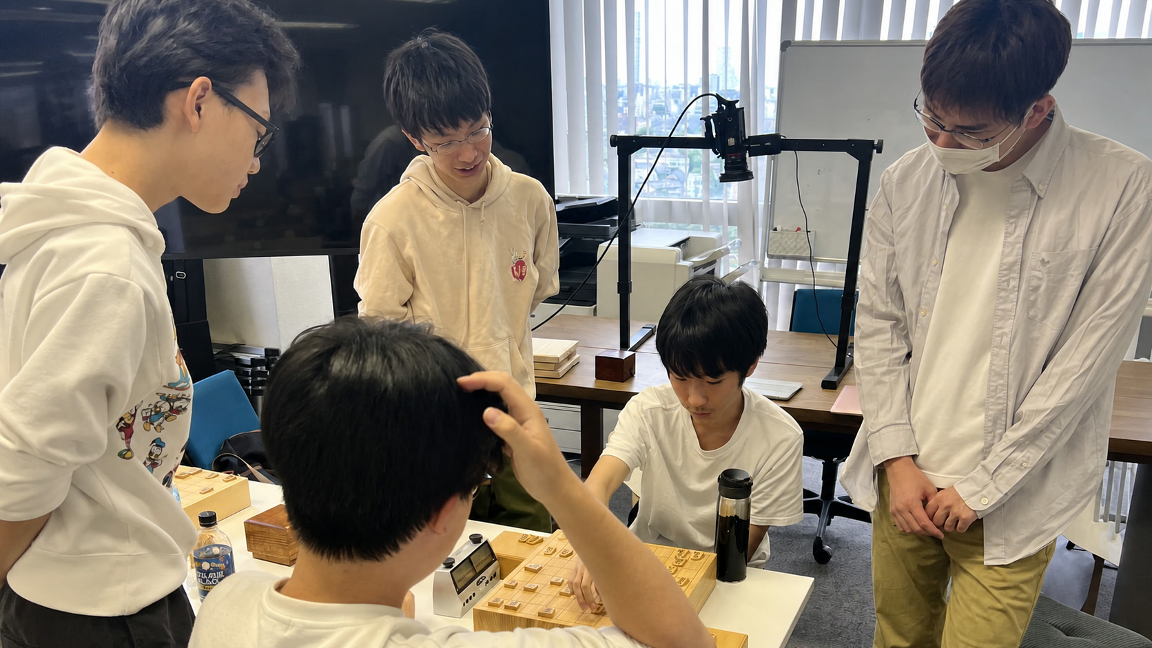 複数人で将棋盤を囲み共同検討を行う様子