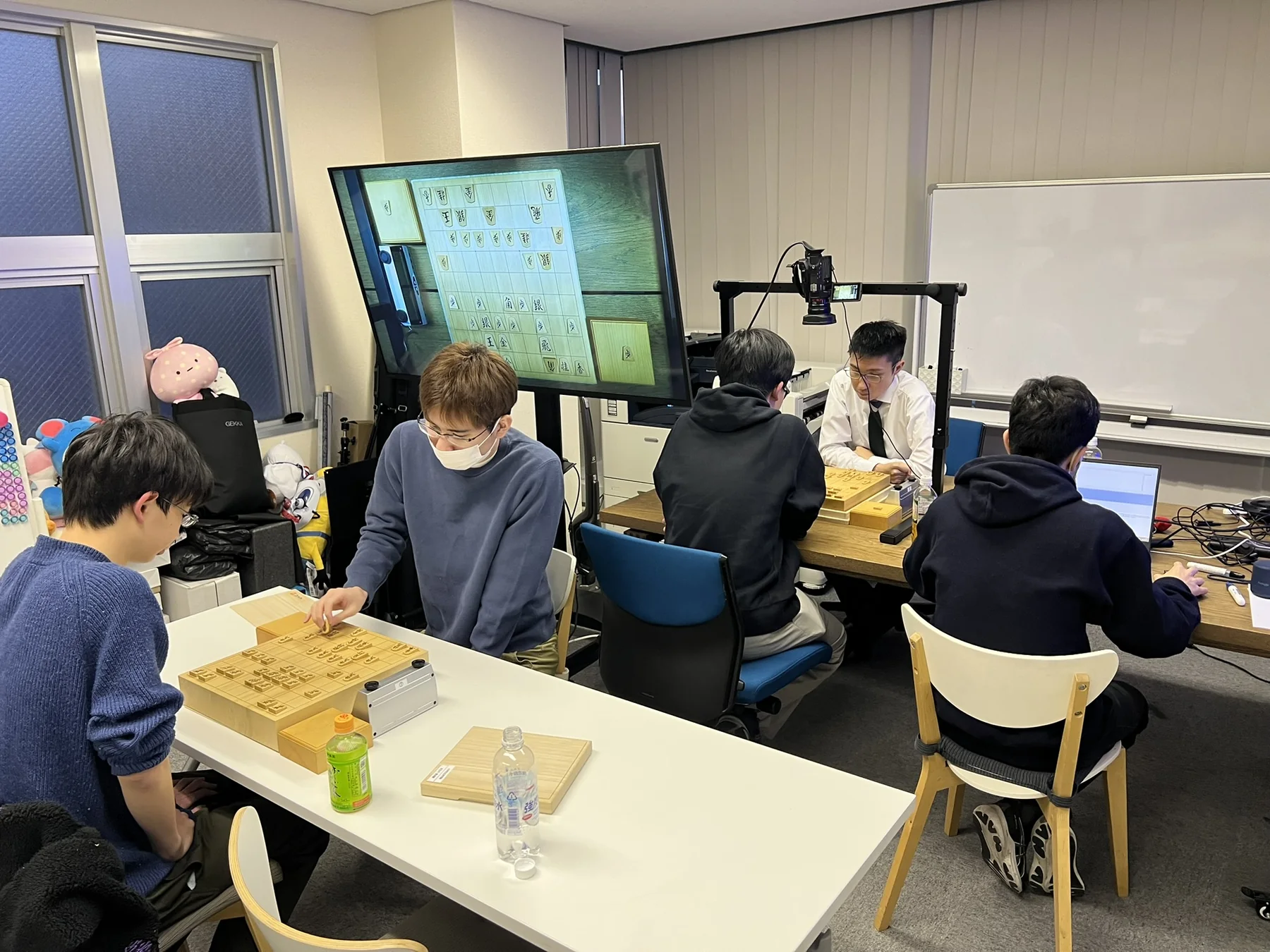 研究会会場で複数組が対局と棋譜分析に取り組む様子